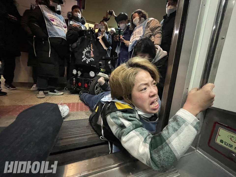 지하철 투쟁 중 문애린 소장이 열차 내 안전바를 한 손으로 붙잡고 시민을 향해 발언하고 있다. 사진 하민지