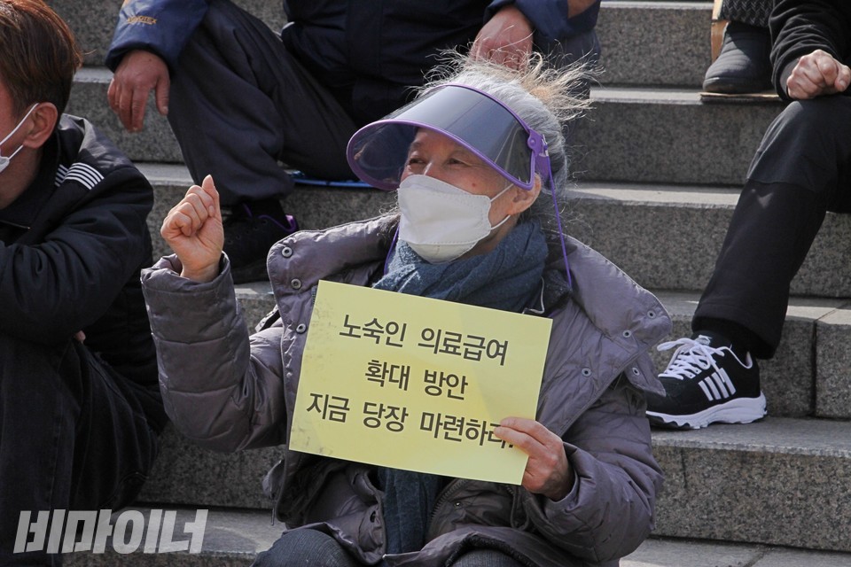 로즈마리 회장이 ‘노숙인 의료급여 확대 방안 지금 당장 마련하라’라는 피켓을 들고 ‘투쟁’을 외치고 있다. 사진 하민지
