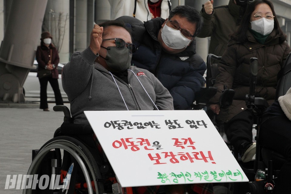이정아 충주사나래장애인자립생활센터 소장이 기자회견에서 ‘투쟁’을 외치고 있다. ‘이동권 없이는 삶도 없다, 이동권을 즉각 보장하라!’라고 적힌 피켓을 목에 걸었다. 사진 하민지