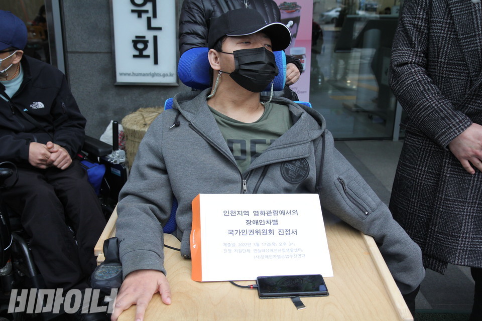 기자회견 참가자의 휠체어 위에 ‘인천 지역 영화관람에서의 장애인 차별 국가인권위원회 진정서'가 놓여 있다. 사진 이슬하