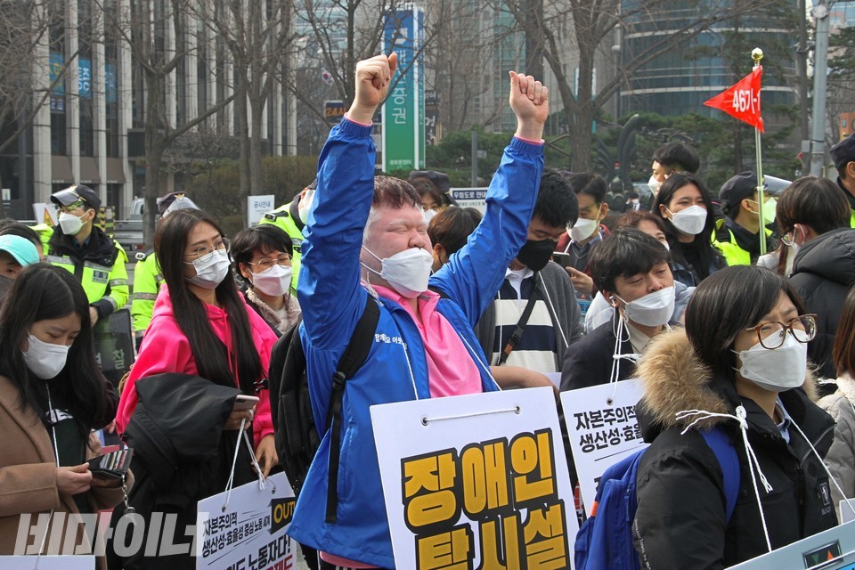 문석영 피플퍼스트서울센터 동료지원가가 행진하며 두 손을 하늘 위로 뻗고 있다. 사진 하민지