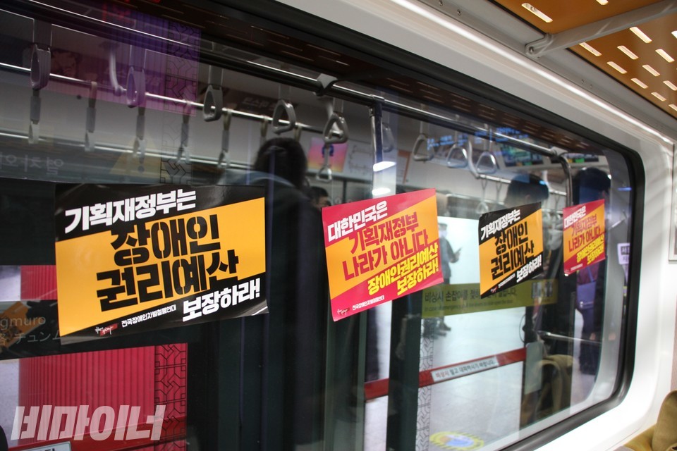 열차 내 창문에 붙은 피켓. ‘기획재정부는 장애인 권리예산 보장하라’, ‘대한민국은 기획재정부 나라가 아니다 장애인권리예산 보장하라’라고 적혀 있다. 사진 하민지