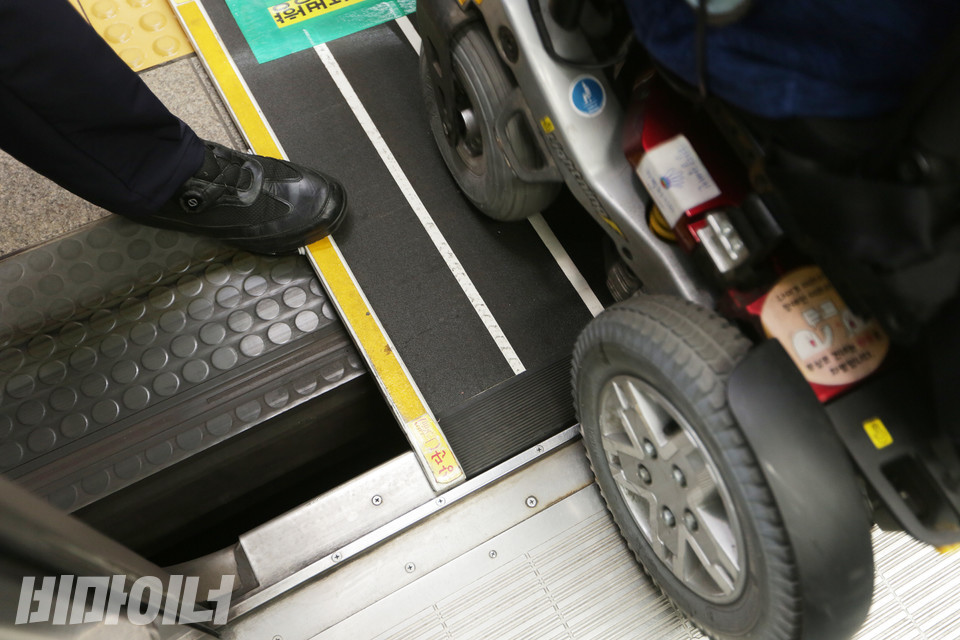 열차와 승강장 사이의 넓은 간격. 이로 인해 휠체어 탄 사람들은 바퀴가 종종 빠지는 사고를 당한다. 서울교통공사 직원이 경사로를 이용해 이동지원을 하고 있다. 사진 강혜민