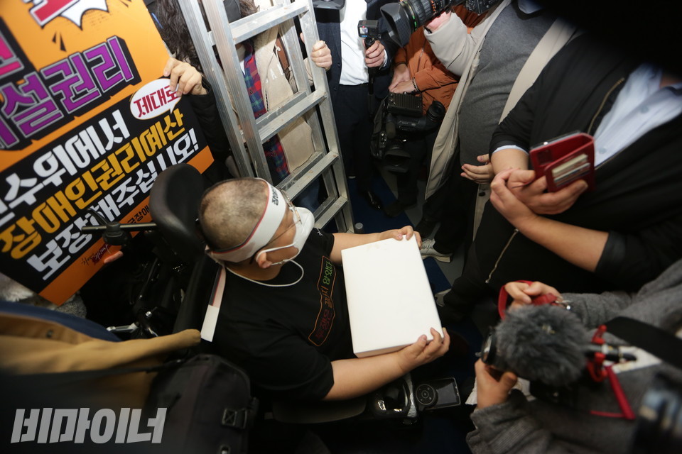 경복궁역에서 혜화역으로 가기 위해 지하철에 탑승한 이형숙 회장. 그의 옆엔 “인수위에서 장애인권리예산 보장해주십시오”라고 적힌 피켓과 사다리가 있다. 사진 강혜민