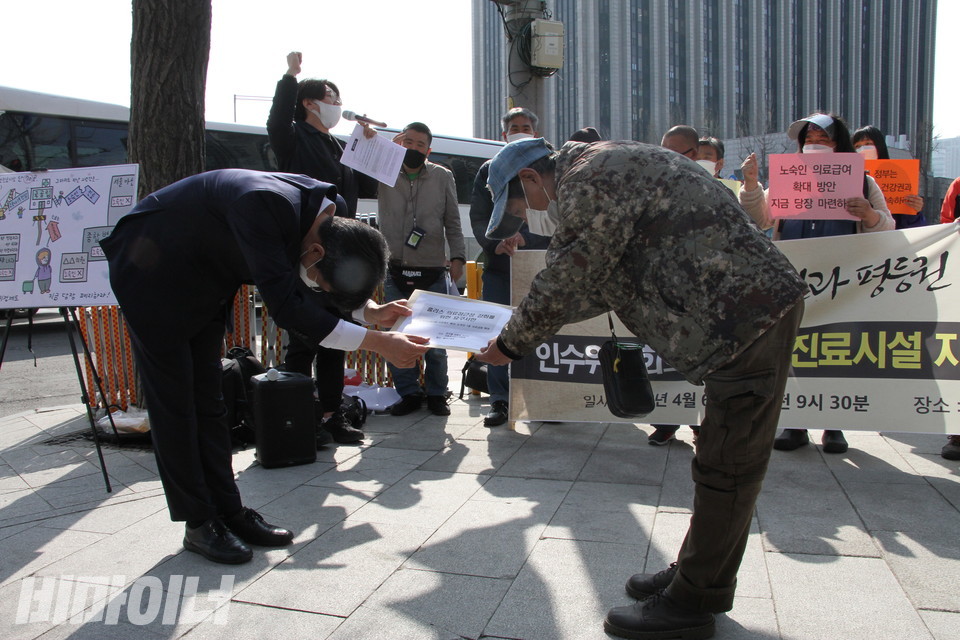 인수위 관계자가 요구서를 받아가는 동안 구호를 외치고 있는 활동가들. 사진 하민지