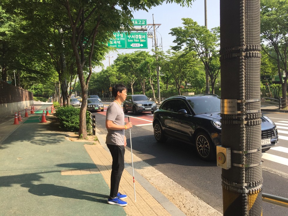 2017년 당시 재직하던 중학교의 학생들이 직접 구청에 민원을 넣어 지하철역에서 학교까지 점자유도블록이 설치됐다. 점자유도블록 위를 걷고 있는 김헌용 씨의 모습. 사진 김헌용