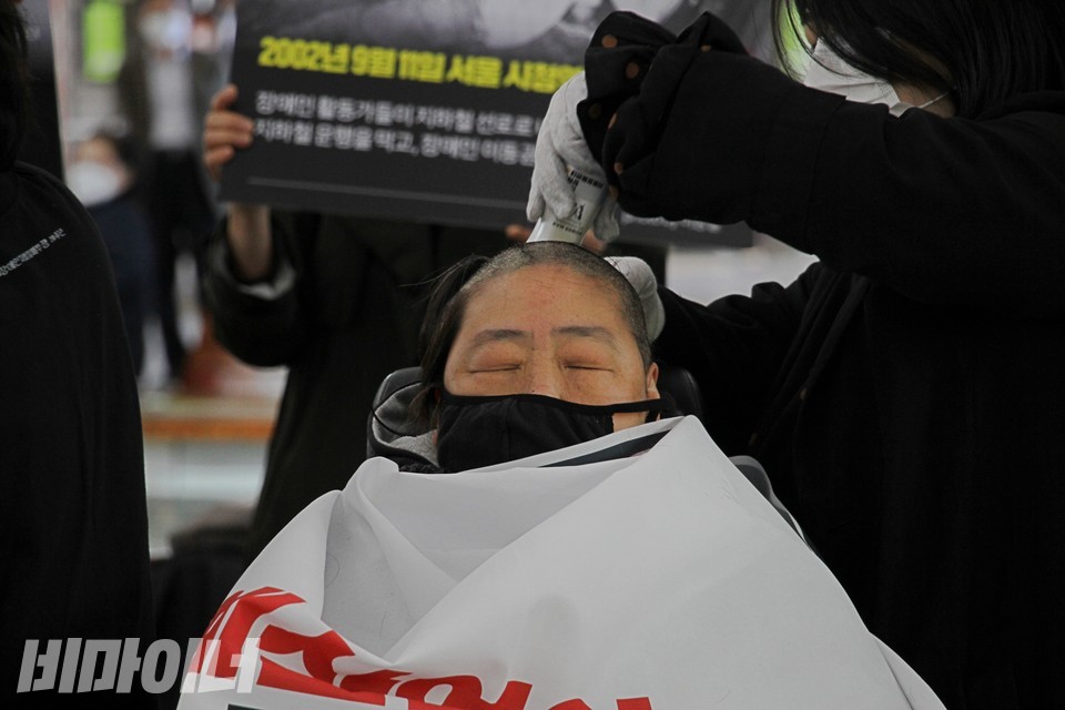 다른 활동가가 차한선 회원의 머리카락을 깎고 있다. 사진 하민지