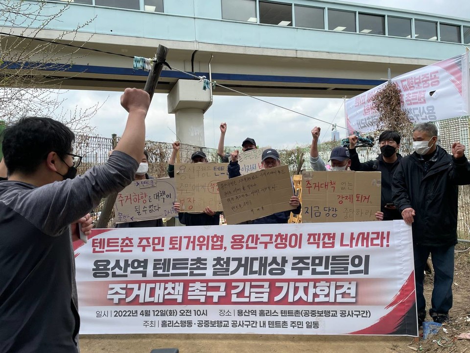 기자회견 현장. 참가자들이 피켓을 들고 ‘투쟁’을 외치고 있다. 현수막에는 ‘텐트촌 주민 퇴거위협, 용산구청이 직접 나서라! 용산역 텐트촌 철거대상 주민들의 주거대책 촉구 긴급 기자회견’이라 적혀 있다. 사진 빈곤사회연대