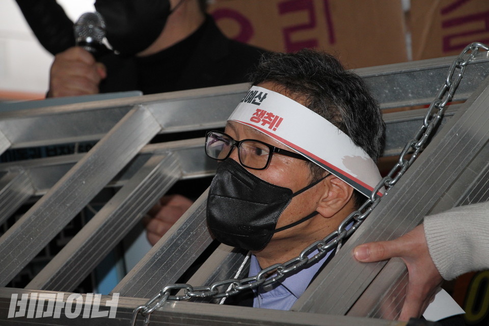 김태현 사무국장의 삭발 전 모습. 사다리와 쇠사슬을 목에 걸었다. 머리에는 ‘장애인권리예산 쟁취’라고 적힌 띠를 둘렀다. 사진 이슬하