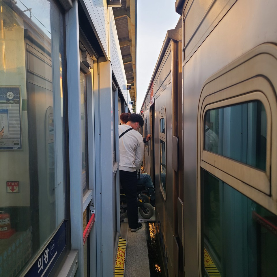 한 휠체어 이용 활동가가 의왕역에서 지하철 타기 선전전을 위해 지하철에 탑승하고 있다. 열차와 승강장 사이 간격이 매우 넓어 위험하다. 사진 경기도420장애인차별철폐공동투쟁단