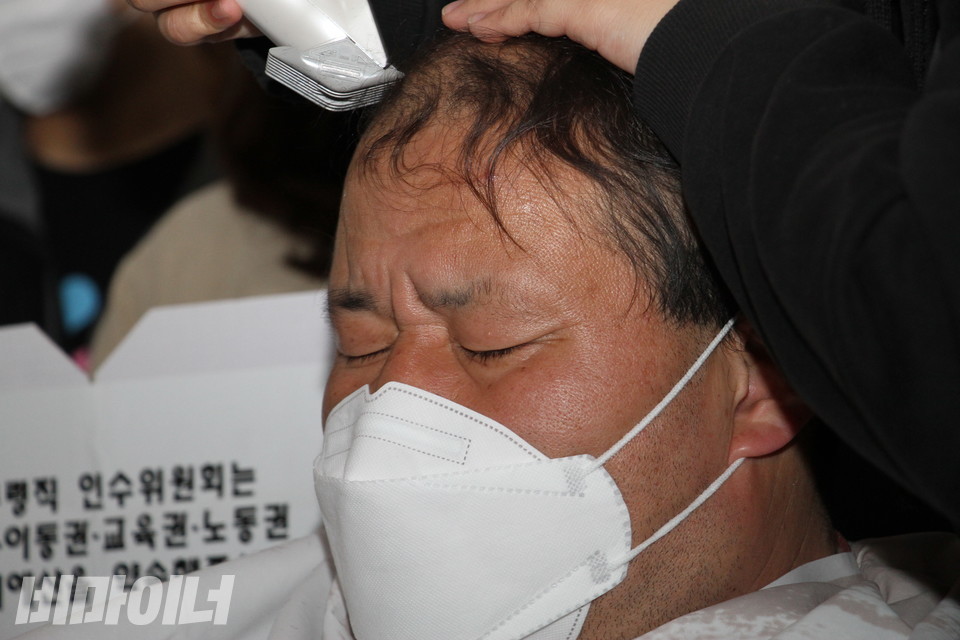 김진석 이음장애인자립생활센터 활동가가 눈을 감고 있다. 다른 활동가가 그의 머리카락을 자르고 있다. 사진 이슬하