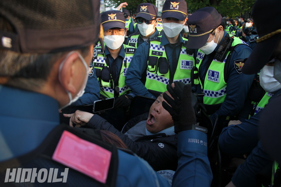 경찰에게 둘러싸인 이규식 서울장애인차별철폐연대 대표가 강하게 항의하고 있다. 사진 이슬하