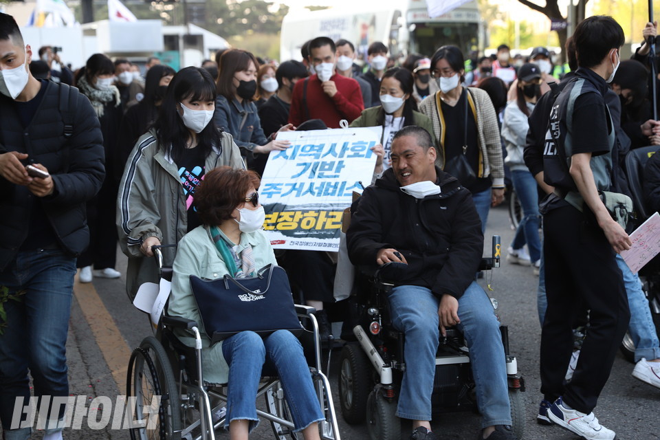행진하는 장애인 활동가들이 서로를 바라보며 활짝 웃고 있다. 사진 강혜민