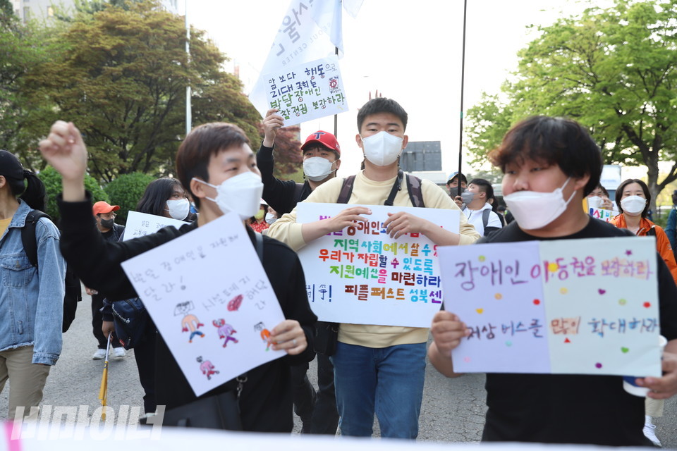 피플퍼스트 활동가들이 피켓을 들고 행진하고 있다. 사진 강혜민