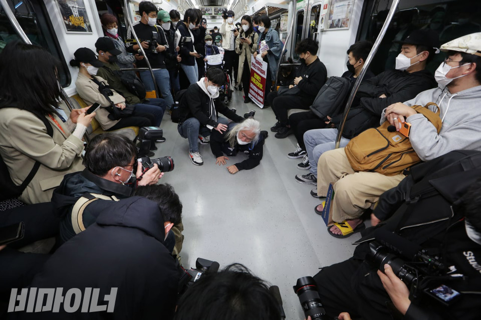 박경석 대표가 지하철에서 오체투지를 하고 있다. 지하철 의자에 앉은 승객들이 그를 바라보고 있다. 사진 이슬하 