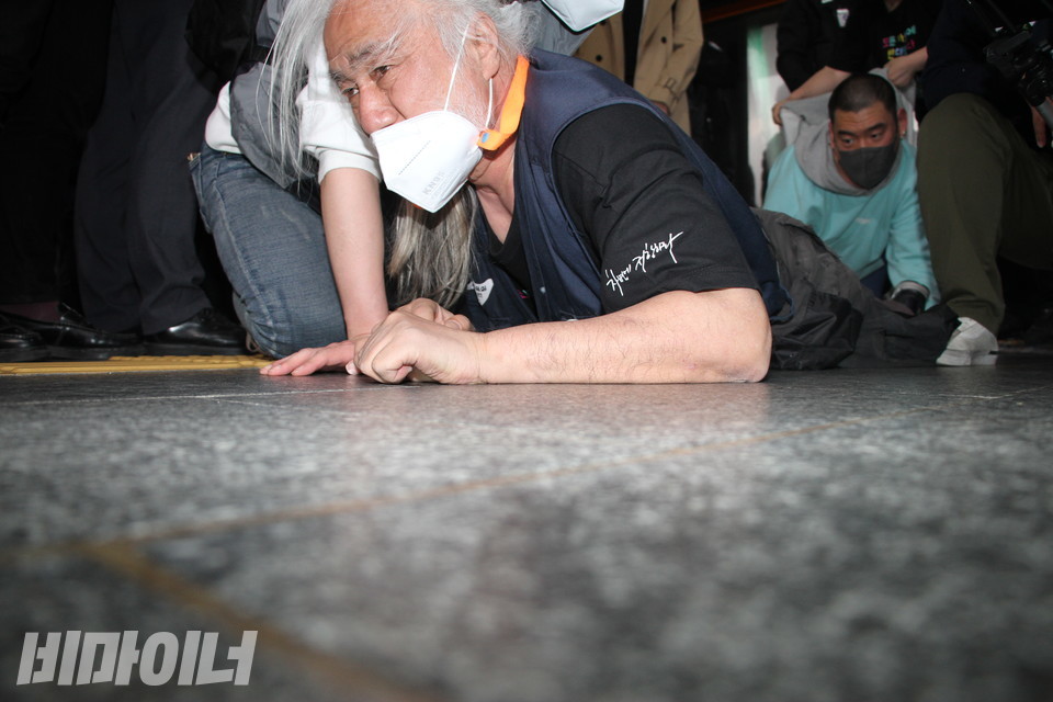 박경석 전국장애인차별철폐연대 상임공동대표가 지하철 승강장 바닥에서 오체투지를 하고 있다. 그의 뒤를 따라 유진우 노들장애인자립생활센터 활동가가 함께 기고 있다. 사진 이슬하 
