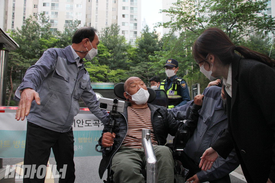이규식 서울장애인차별철폐연대 대표가 아파트 단지 안으로 들어가려 하자, 경찰과 관리사무소 직원들이 그를 제지하고 있다. 사진 이슬하
