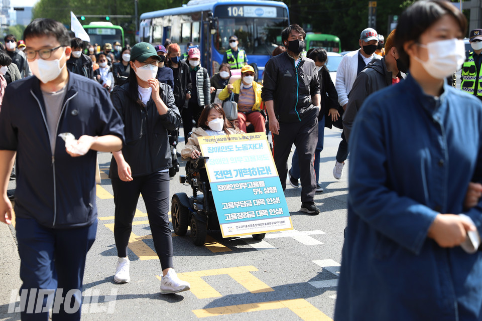 “장애인도 노동자다. 장애인 의무고용제도 전면 개혁하라”고 적힌 피켓을 걸고 행진하는 장애인 노동자. 사진 강혜민