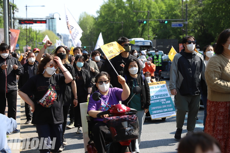 “이것도 노동이다”라고 적힌 노란 손깃발을 흔들며 행진하는 사람들. 사진 강혜민