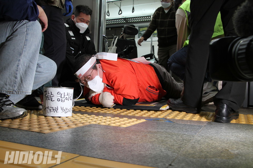 이형숙 서울시협의회 회장이 힘겹게 지하철에서 내리고 있다. 앞에는 '국회는 응답하라'라는 글이 쓰인 깡통이 놓여 있다. 사진 허현덕