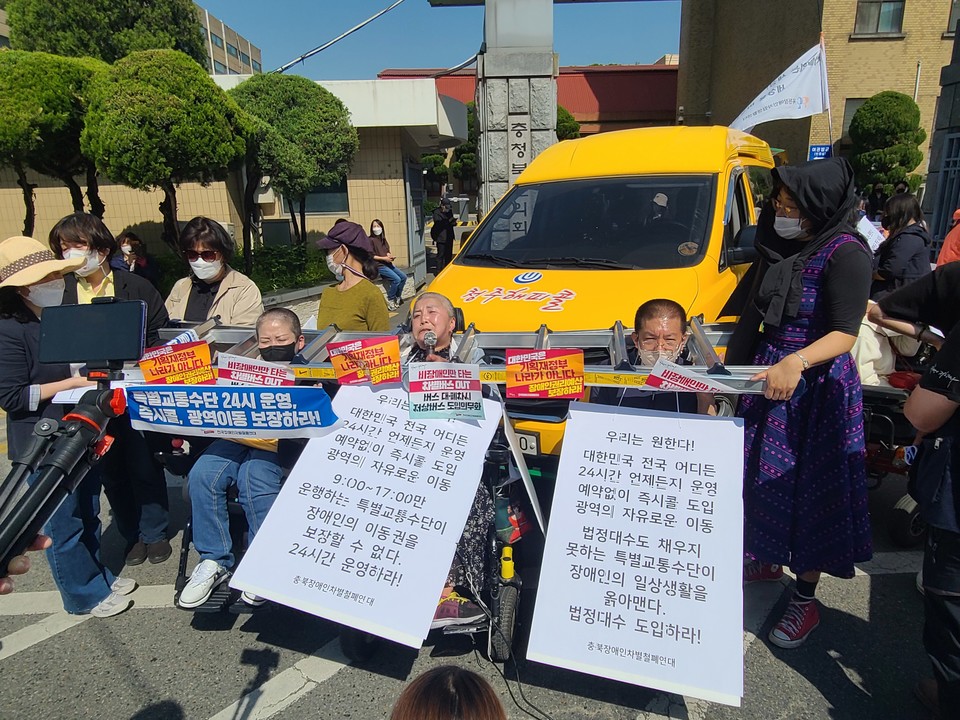 청주 해피콜을 점거한 활동가들. 왼쪽부터 임경미 소장, 문경희 세종장애인차별철폐연대 공동대표, 권달주 대표가 목에 사다리를 걸고 해피콜을 점거했다. 사진 서울장애인차별철폐연대