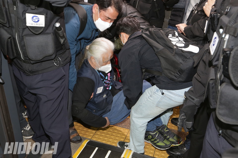 박경석 전국장애인차별철폐연대 상임공동대표가 두 사람의 지원을 받아 휠체어에서 내려오고 있다. 사진 이슬하