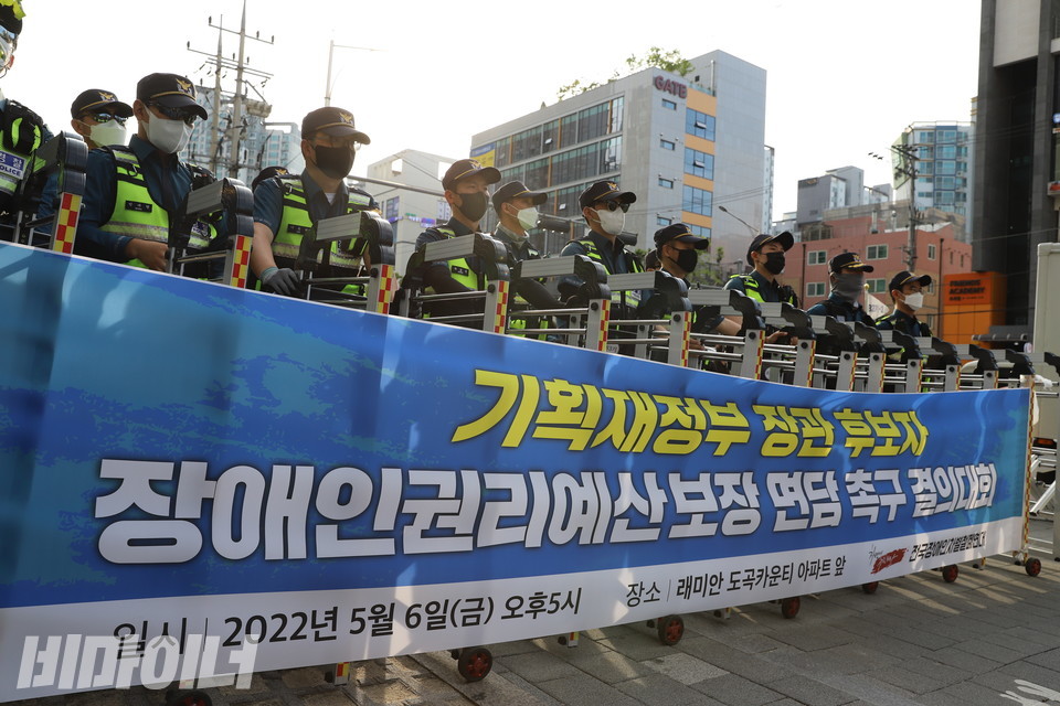 현수막에 ‘기획재정부 장관 후보자 장애인권리예산 보장 면담 촉구 결의대회’라고 적혀 있다. 그 뒤에 경찰이 친 울타리와 경찰 여러 명이 보인다. 사진 하민지
