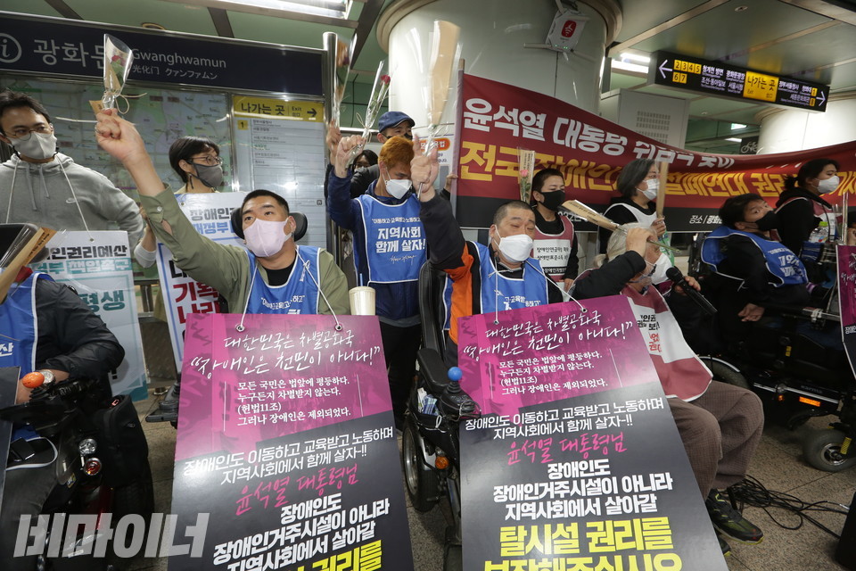 10일 오전 8시, 광화문역 승강장에 모인 장애인 활동가들. “투쟁”을 외치며 치켜든 손에는 장미꽃이 들려 있다. 사진 강혜민 