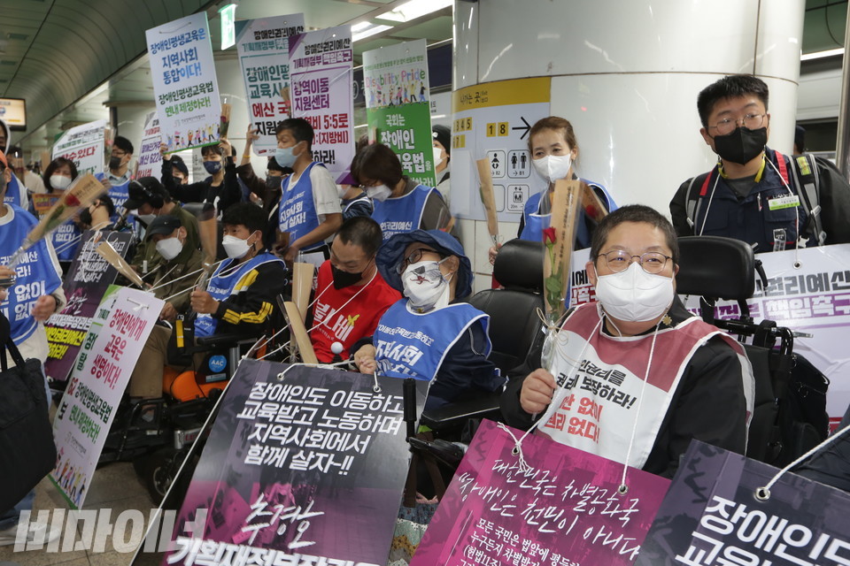 10일 오전 8시, 광화문역 승강장에 모인 장애인 활동가들. 손에는 장미꽃이 들려 있다. 사진 강혜민