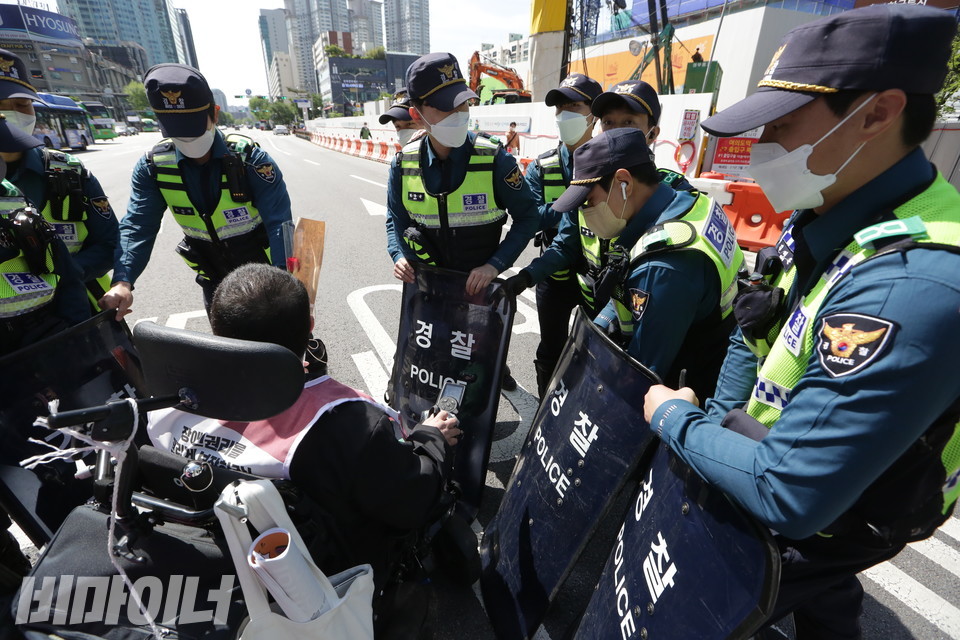 행진하는 장애인 활동가를 막아선 경찰들. 사진 이슬하 