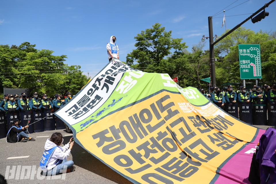 장애인권리예산 보장을 촉구하는 대형 현수막을 펼쳐 든 전장연 활동가들. 사진 강혜민