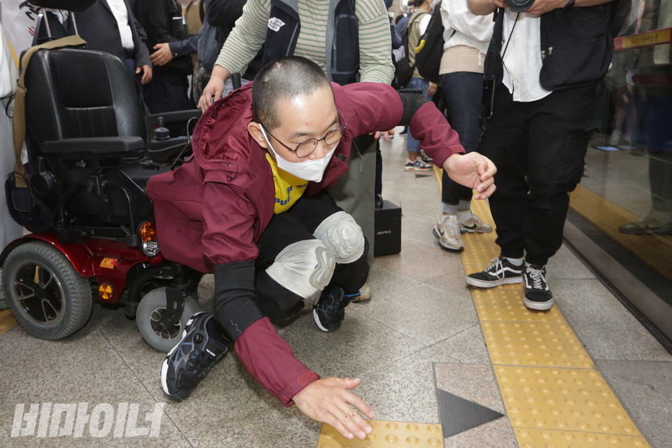 이상진 용산행복장애인자립생활센터 권리중심공공일자리 노동자가 휠체어에서 바닥으로 내려오고 있다. 사진 이슬하