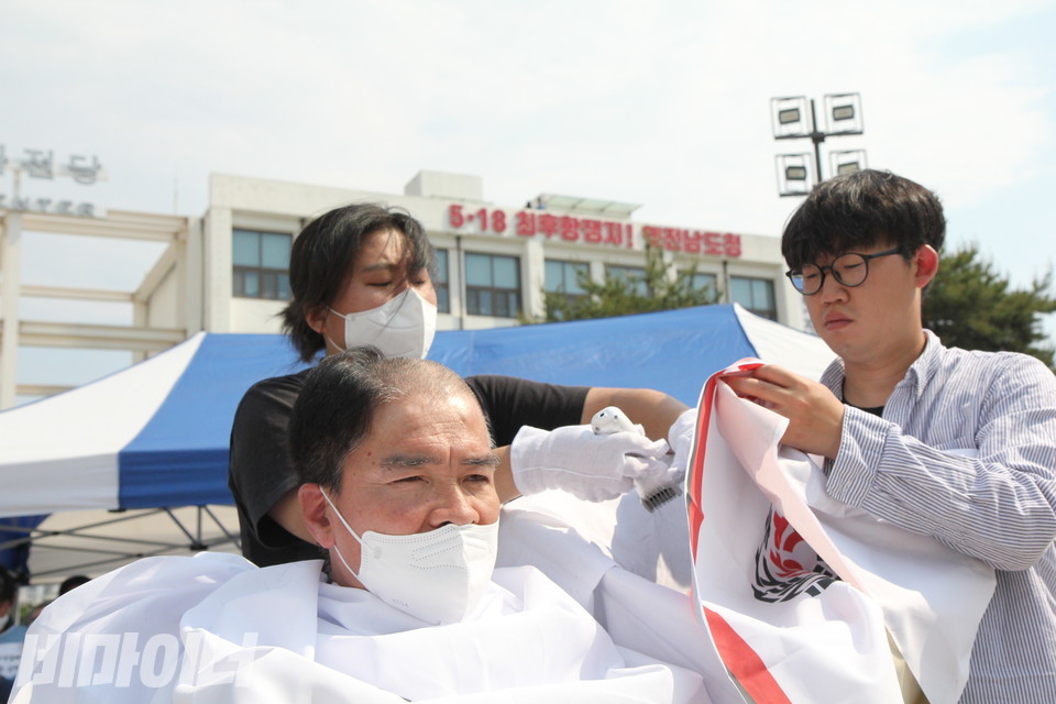 박영석 오방장애인자립생활센터 권리옹호활동가의 머리가 반쯤 잘려 있다. 그 뒤로는 '5.18 최후항쟁지! 옛 전남도청'이라는 글씨가 보인다. 사진 이슬하