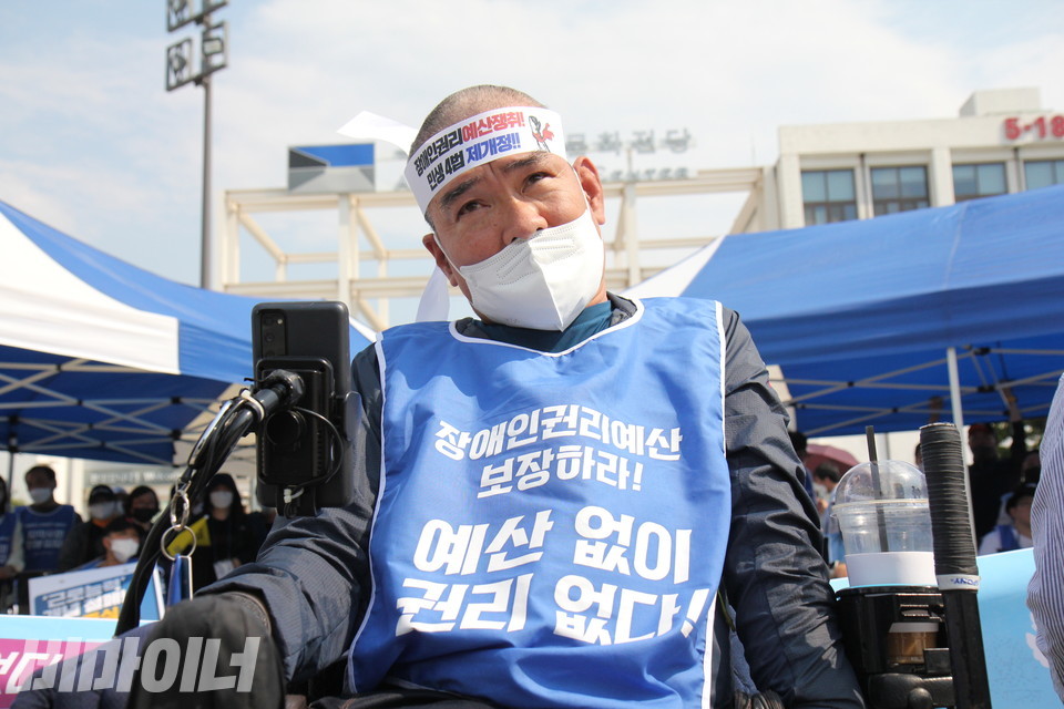 삭발을 마친 박영석 오방장애인자립생활센터 권리옹호활동가가 머리띠를 두르고 있다. 머리띠에는 '장애인권리예산 쟁취, 민생 4법 제개정!이라고 쓰여 있다. 사진 이슬하