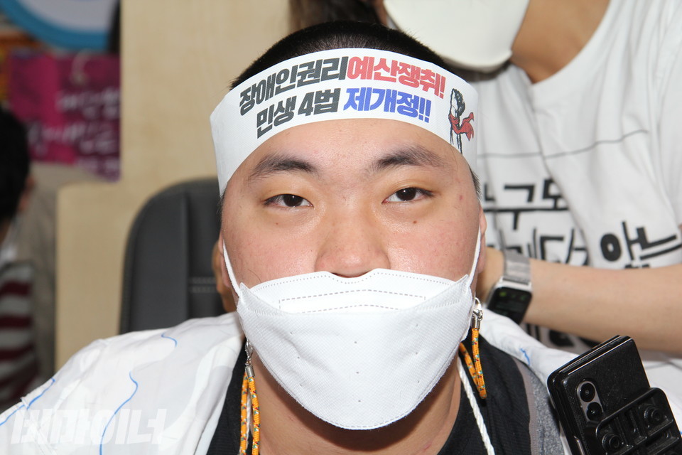 삭발을 마친 김영수 활동가가 머리에 “장애인권리예산 쟁취! 민생4법 제개정!”이라고 적힌 띠를 두르고 있다. 사진 이슬하