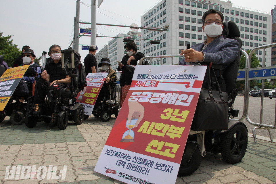 기자회견 참가자가 ‘중증장애인 3년 시한부 선고’라는 팻말을 들고 있다. 사진 허현덕