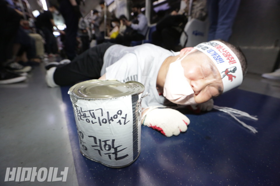지난 13일 이선희 충북뇌병변장애인인권협회 회장이 오체투지를 하며 지하철 바닥을 기고 있다. 이날 아침 삭발한 그의 머리가 짧다. 이 회장 앞에는 ‘예산 없는 껍데기뿐인 장애인 권리’를 비유하는 빈 깡통이 놓여 있다. 사진 강혜민