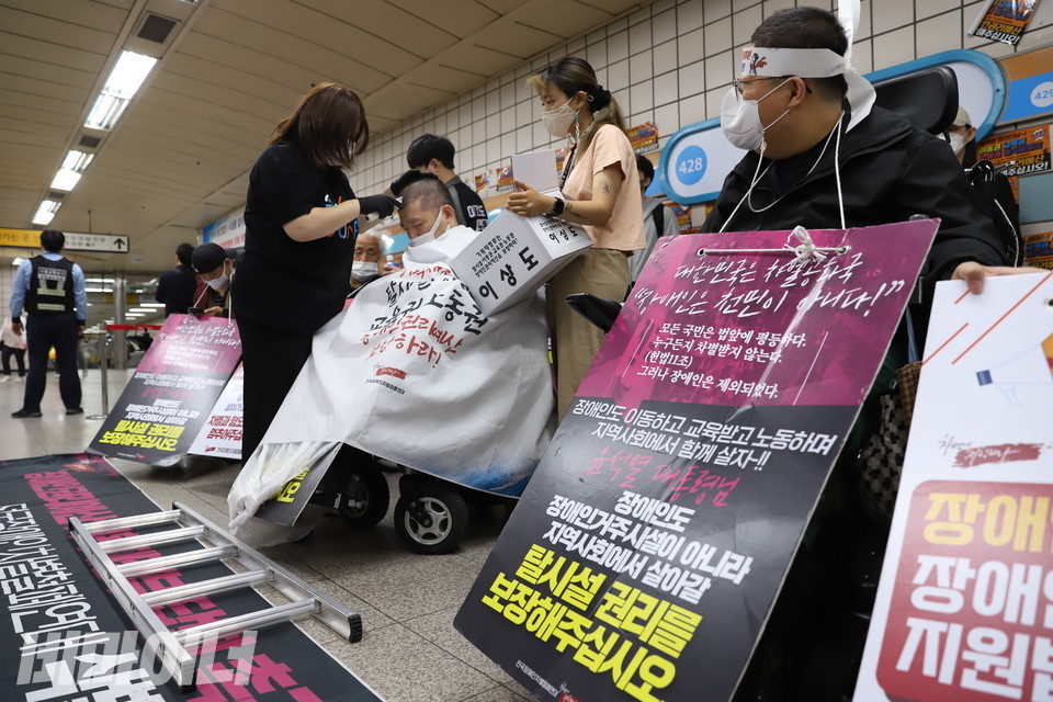 삼각지역에서 삭발 투쟁을 하는 이상도 활동가. 그의 앞에는 철제 사다리가 놓여 있다. 사진 강혜민