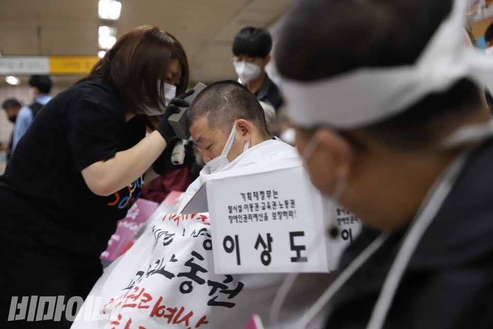 이형숙 서울시장애인자립생활센터협의회 대표가 삭발하는 이상도 활동가를 바라보고 있다. 사진 강혜민