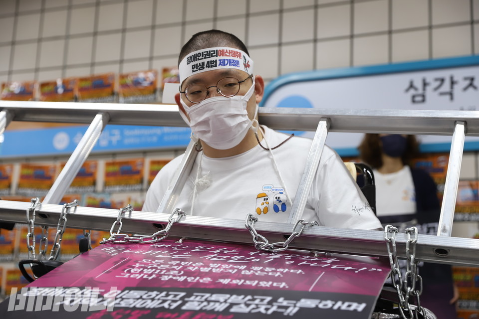 삭발을 마친 이상도 활동가. 쇠사슬을 두른 사다리를 목에 걸고 있다. 사진 강혜민