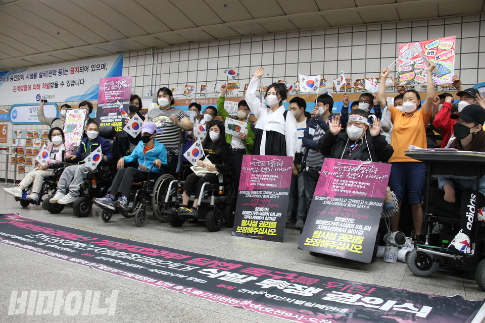 삼각지역 1-1 승강장 앞. 장애인 활동가들이 태극기를 들고 “장애인권리 쟁취 만세”를 외치고 있다. 가운데에 하얀 저고리와 까만 치마를 입은 신선옥 소장이 보인다. 사진 하민지