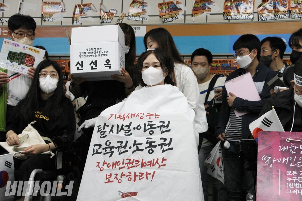 삭발을 준비 중인 신선옥 소장. “기획재정부는 탈시설, 이동권, 교육권, 노동권 장애인권리예산 보장하라”라고 적힌 보자기를 몸에 둘렀다. 사진 하민지