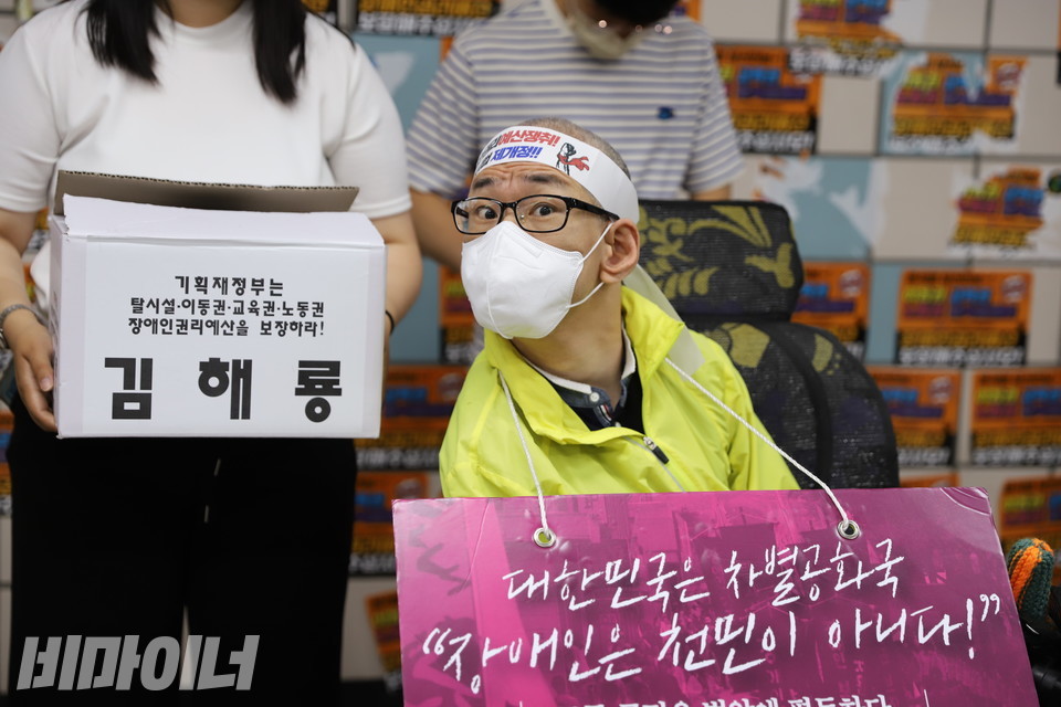 삭발을 마친 김해룡 동작장애인자립생활센터 소장. 그는 ‘대한민국은 차별공화국, 장애인은 천민이 아니다!’라고 쓰여 있는 피켓을 목에 걸고 있다. 사진 허현덕