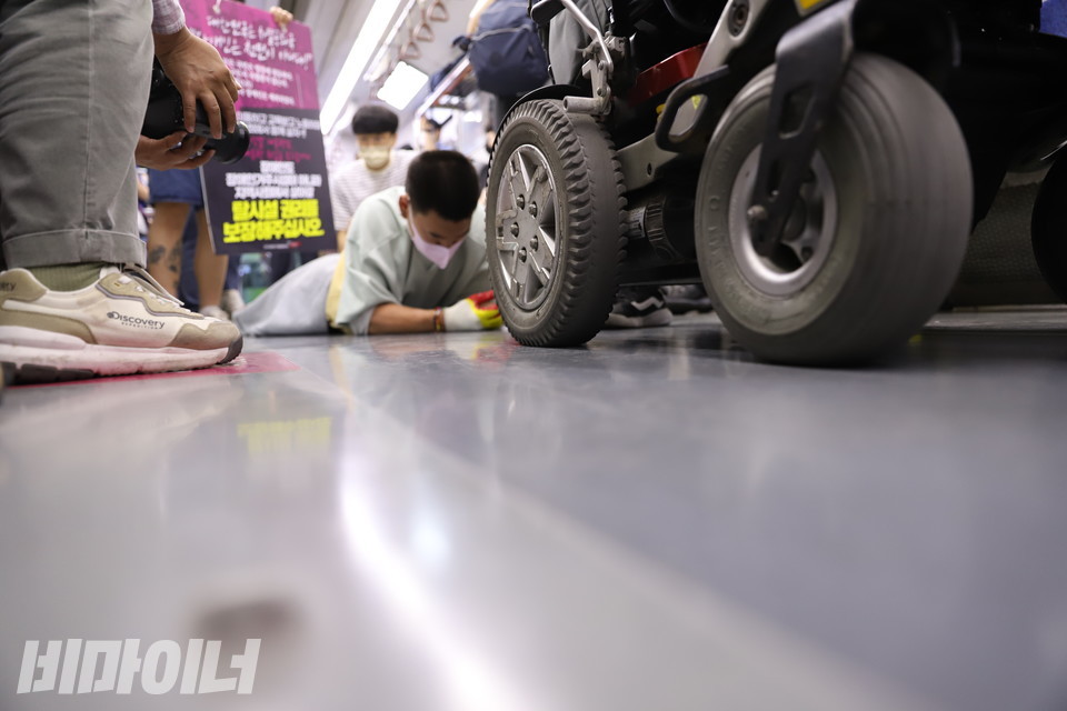 유진우 노들장애인자립생활센터 활동가는, 삼각지역에서 한성대입구역을 경유해 혜화역까지 이동하는 동안 지하철 바닥을 기었다. 유 활동가 앞으로 김해룡 소장의 휠체어가 보인다. 사진 허현덕 