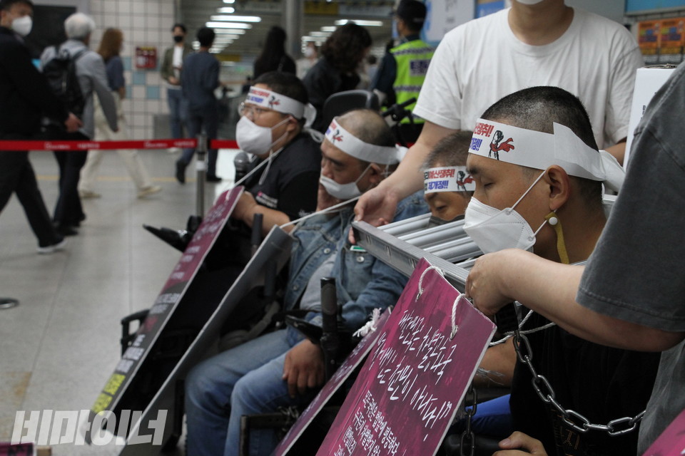 삼각지역에서 이형숙 서울시장애인자립생활센터협의회 회장이 발언하고 있다. 그 옆으로 시민들이 지나가고 있다. 사진 허현덕