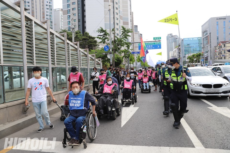행진하는 활동가들과 한 줄로 선 경찰들. 사진 하민지