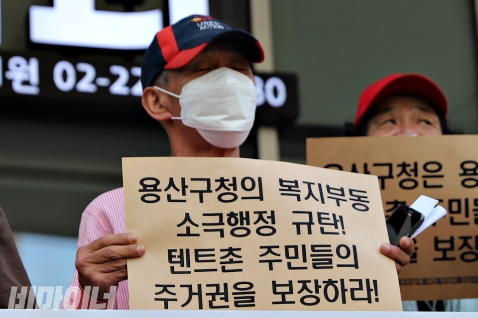 ‘용산구청의 복지부동 소극행정 규탄! 텐트촌 주민들의 주거권을 보장하라!’라고 적힌 피켓을 들고 있는 박 씨. 사진 하민지