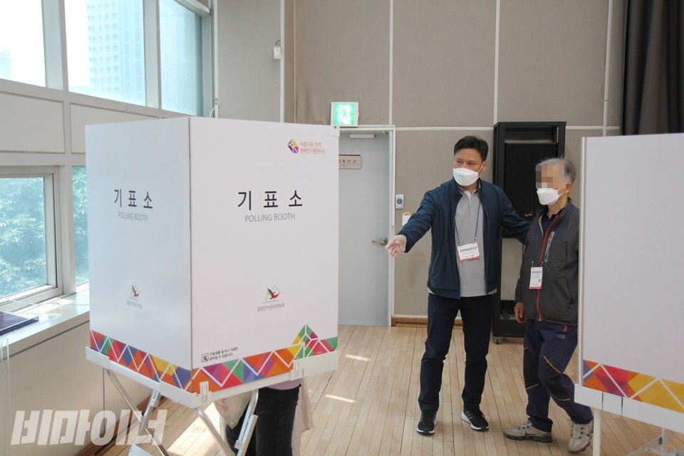 김동옥 씨가 투표보조인과 함께 기표소에 들어가 있는 상황에서 사전투표 관리관이 참관인을 입회시키고 있다. 사진 이슬하