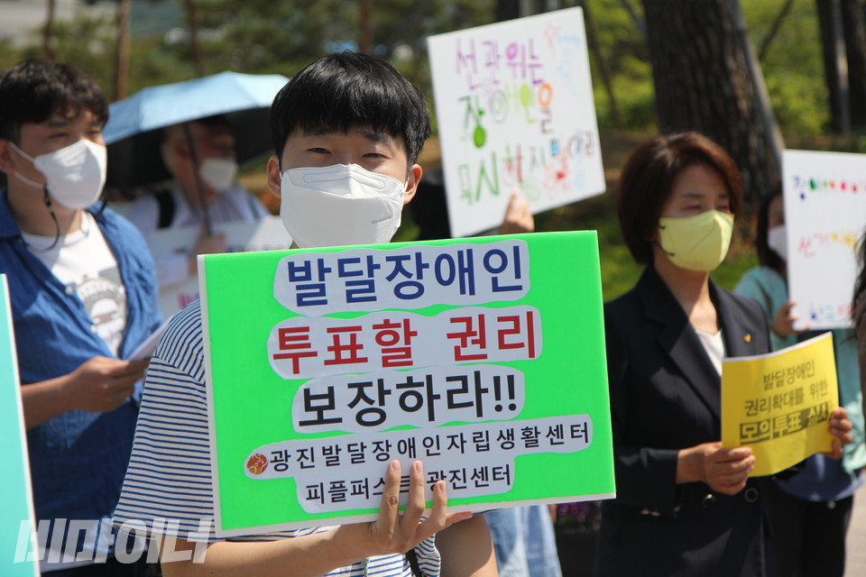 피플퍼스트광진센터 활동가가 “발달장애인 투표할 권리 보장하라”고 적힌 피켓을 들고 있다. 사진 이슬하