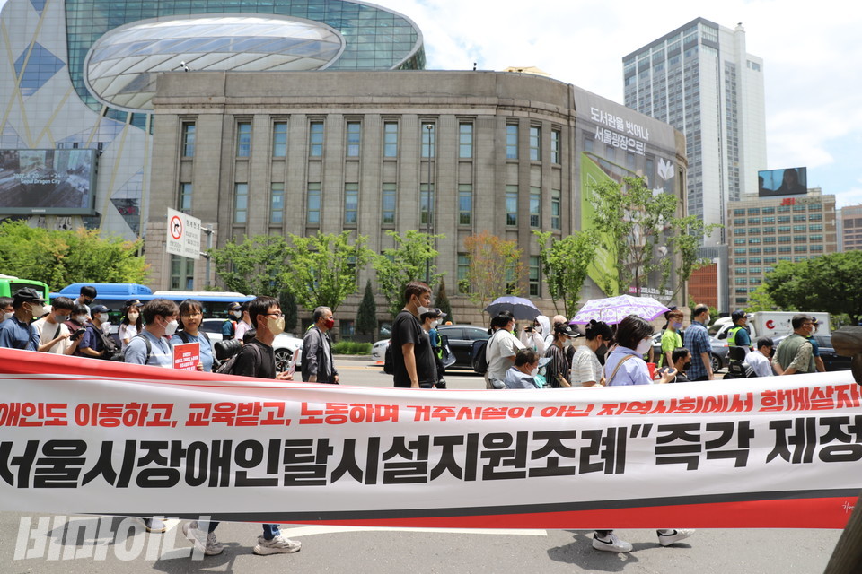 참가자들이 ‘장애인도 이동하고 교육받고 노동하며 거주시설이 아닌 지역사회에서 함께 살자! 서울시장애인탈시설지원조례 즉각 제정’이라는 글이 쓰인 현수막을 들고 행진하고 있다. 사진 허현덕